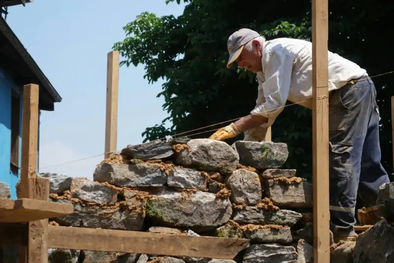 Artisan réparant une structure de maçonnerie ancienne en briques