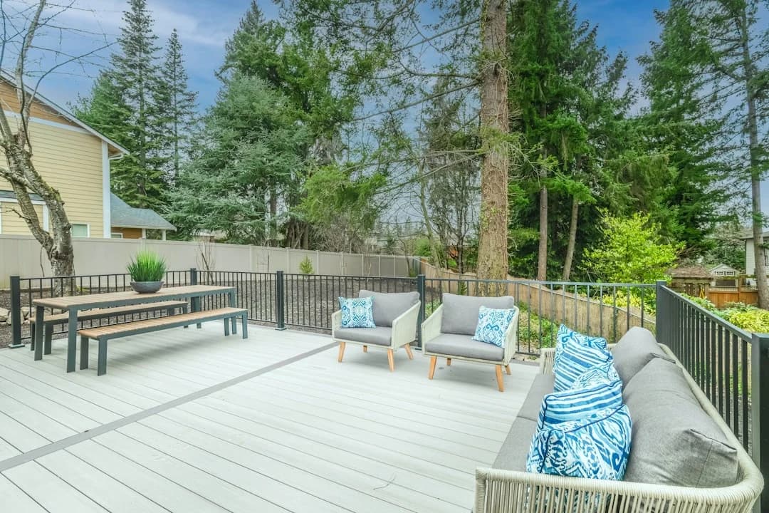 Modern composite deck with outdoor patio furniture surrounded by lush greenery