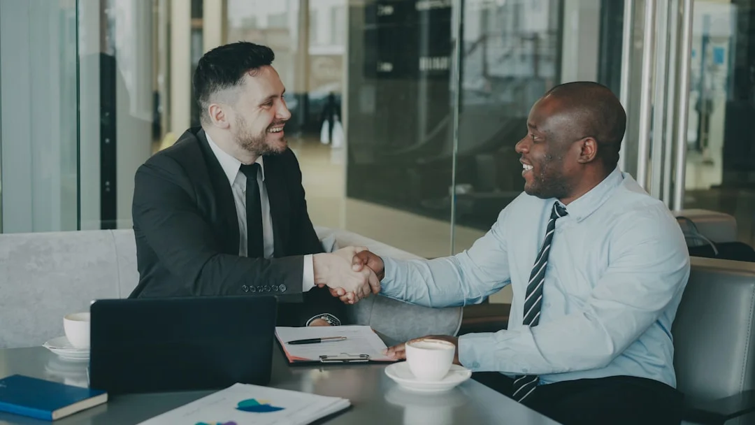 Two professionals shaking hands after signing a renovation contract
