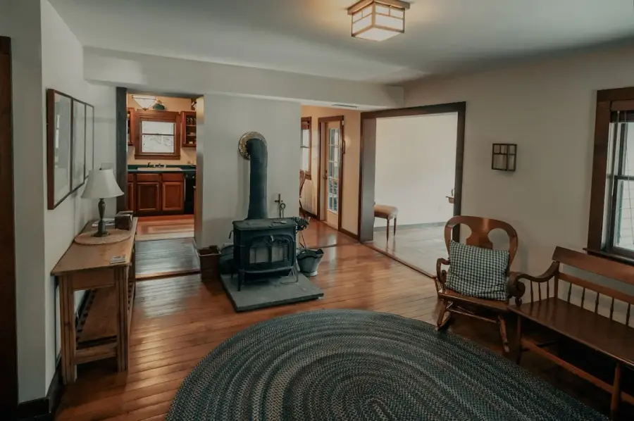 Intérieur chaleureux d'une maison de campagne ancienne avec poêle à bois et plancher de bois franc d'origine