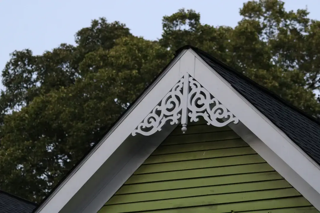 Ornement de bois découpé au pignon d'une maison ancienne, dentelle architecturale