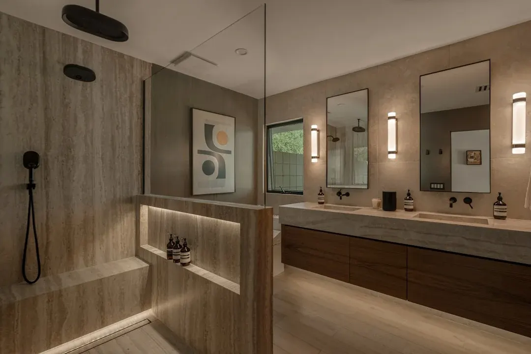 Salle de bain spa avec vanité en pierre, douche à l'italienne et éclairage d'ambiance
