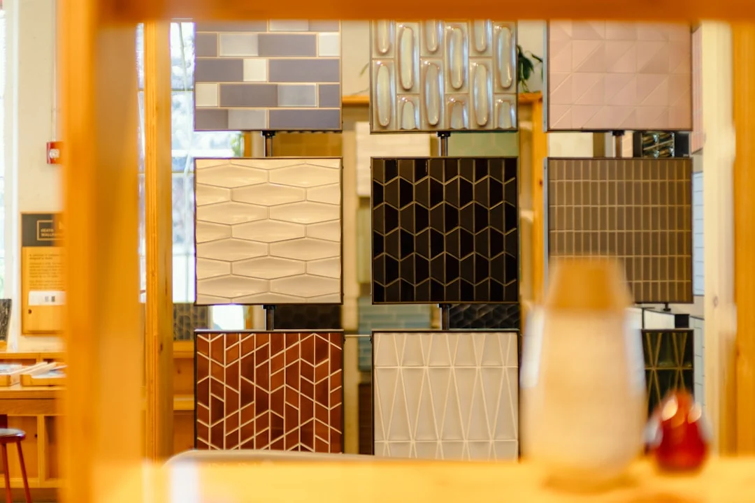 Wall of tile samples with varied patterns and textures in a renovation showroom